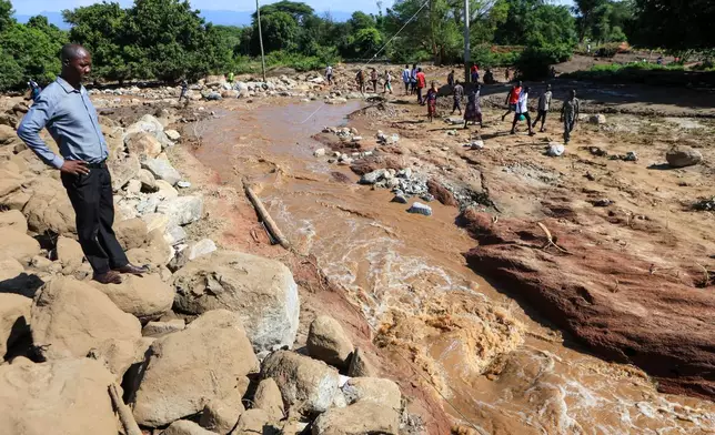 People inspect the scene of a landslide that killed scores in the hilly area of Chesongoch in Elgeyo Marakwet county, western Kenya, Sunday, Nov. 2, 2025. (AP Photo/Andrew Kasuku)