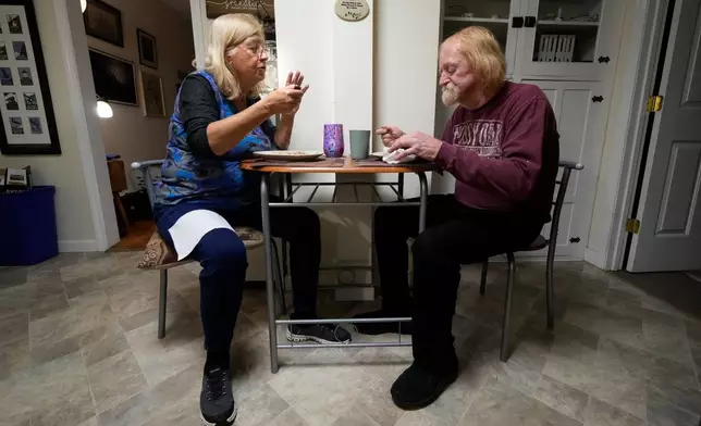 Marsha, left, and Kirk Luce, both patients at Ammonoosuc Community Health Services, eat dinner, Thursday, Oct. 23, 2025, at their home in Franconia, N.H. (AP Photo/Robert F. Bukaty)