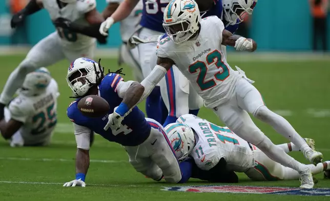 Buffalo Bills' James Cook (4) fumbles against Miami Dolphins' Jack Jones (23) during the first half of an NFL football game, Sunday, Nov. 9, 2025, in Miami Gardens, Fla. (AP Photo/Lynne Sladky)
