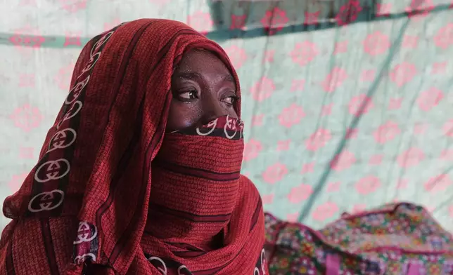 Nadra Mohamed Ahmed, 21, reacts during an interview with The Associated Press inside her tent at the newly established El-Afadh camp in Al Dabbah, Sudan's northern state, Monday, Nov. 17, 2025. (AP Photo/Marwan Ali)