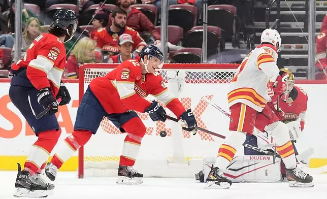 Florida Panthers defenseman Gustav Forsling (42) and Florida Panthers goaltender Daniil Tarasov (40) can't stop a shot by Calgary Flames center Nazem Kadri (91), for the Flames fourth goal, during the second period of an NHL hockey game, Friday, Nov. 28, 2025, in Sunrise, Fla. (AP Photo/Rebecca Blackwell)