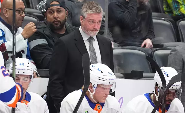 New York Islanders head coach Patrick Roy looks on from the team box in the second period of an NHL hockey game against the Colorado Avalanche Sunday, Nov. 16, 2025, in Denver. (AP Photo/David Zalubowski)