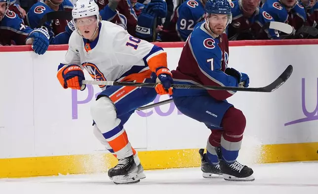 New York Islanders right wing Simon Holmstrom, left, pursues the puck with Colorado Avalanche defenseman Devon Toews in the second period of an NHL hockey game, Sunday, Nov. 16, 2025, in Denver. (AP Photo/David Zalubowski)