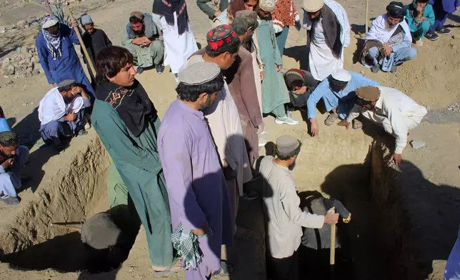 Locals prepare graves for victims of an overnight attack on a home that, according to an Afghan government spokesman, was carried out by Pakistan, in the Gurbaz district of Khost province, Afghanistan, Tuesday, Nov. 25, 2025. (AP Photo/Saifullah Zahir)