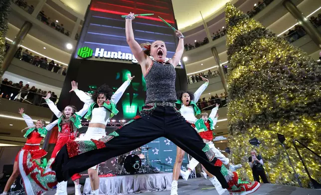 JoJo Siwa performs as shoppers watch at Mall of America for Black Friday deals, Friday, Nov. 28, 2025, in Bloomington, Minn. (AP Photo/Adam Bettcher)