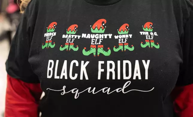 The shirt of a woman who has matching shirts with 4 other friends and all shop together on Black Friday as shoppers browse through Kohl's department store for Black Friday looking for deals, Friday, Nov. 28, 2025, in Woodstock, Ga. (AP Photo/Megan Varner)