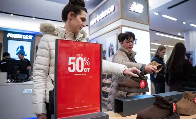 Black Friday shoppers look at shoes at Macy's flagship store in New York on Friday, Nov. 28, 2025. (AP Photo/Angelina Katsanis)