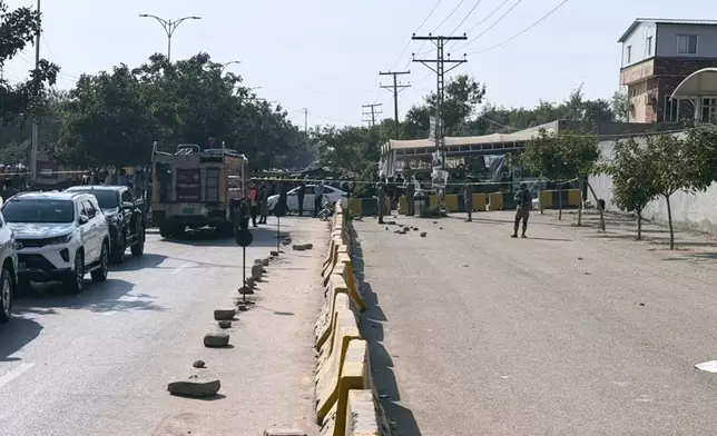 Pakistani security officials stand guard after a powerful car bomb exploded outside a district court in Islamabad, Pakistan, Tuesday, Nov. 11, 2025. (AP Photo/Mohammad Yousuf)