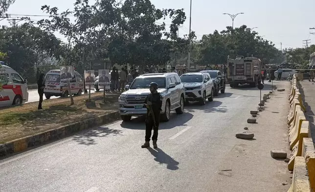 Pakistani security officials stand guard after a powerful car bomb exploded outside a district court in Islamabad, Pakistan, Tuesday, Nov. 11, 2025. (AP Photo/Mohammad Yousuf)