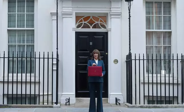 Britain's Chancellor of the Exchequer Rachel Reeves poses on the doorstep of 11 Downing Street with her ministerial red box before heading to the House of Commons to deliver her Budget speech in London, Wednesday, Nov. 26, 2025. (AP Photo/Kirsty Wigglesworth)