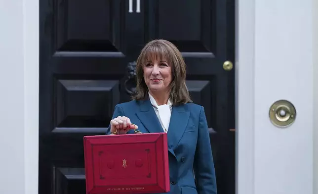 Britain's Chancellor of the Exchequer Rachel Reeves poses on the doorstep of 11 Downing Street with her ministerial red box before heading to the House of Commons to deliver her Budget speech in London, Wednesday, Nov. 26, 2025. (AP Photo/Kirsty Wigglesworth)