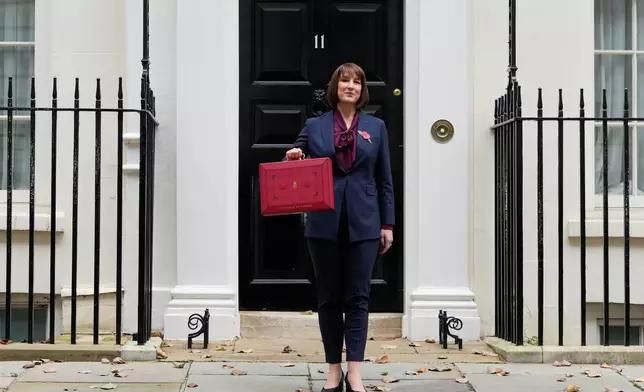 FILE - Britain's Chancellor of the Exchequer, Rachel Reeves, holds up the traditional red ministerial box containing her budget speech, as she poses for the media outside No 11 Downing Street, before departing to the House of Commons to deliver the budget in London, Wednesday, Oct. 30, 2024. (AP Photo/Kirsty Wigglesworth, File)