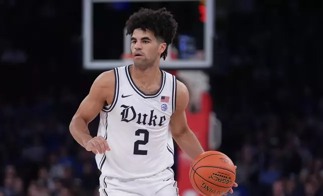 Duke's Cayden Boozer (2) looks to pass during the first half of an NCAA college basketball game against Kansas Tuesday, Nov. 18, 2025, in New York. (AP Photo/Frank Franklin II)