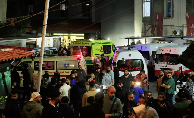 People gathering next of ambulances outside a hospital where they brought the victims of the Israeli strike that hit the Ein el-Hilweh refugee camp in the southern port city of Sidon, Lebanon, Tuesday, Nov. 18, 2025. (AP Photo/Mohammed Zaatari)