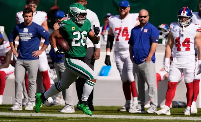 Philadelphia Eagles running back Saquon Barkley (26) runs for a touchdown during the first half of an NFL football game against the New York Giants on Sunday, Oct. 26, 2025, in Philadelphia. (AP Photo/Chris Szagola)