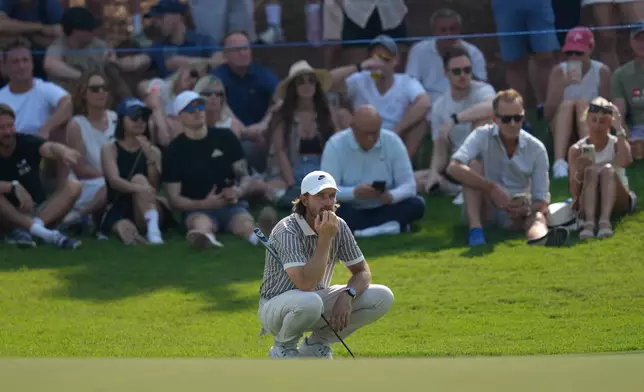 Tommy Fleetwood of England squats as he waits for his turn on 5th green during the second round of World Tour Golf Championship at Jumeirah Golf Estates, in Dubai, United Arab Emirates, Friday, Nov. 14, 2025. (AP Photo/Altaf Qadri)
