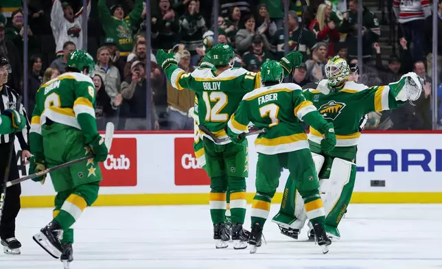 Minnesota Wild goaltender Jesper Wallstedt (30) is congratulated after the teams shootout win after an NHL hockey game against the Carolina Hurricanes Wednesday, Nov. 19, 2025, in St. Paul, Minn. (AP Photo/Matt Krohn)