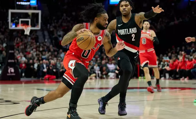 Chicago Bulls guard Coby White, left, dribbles past Portland Trail Blazers guard Caleb Love during the second half of an NBA basketball game in Portland, Ore., Wednesday, Nov. 19, 2025. (AP Photo/Craig Mitchelldyer)