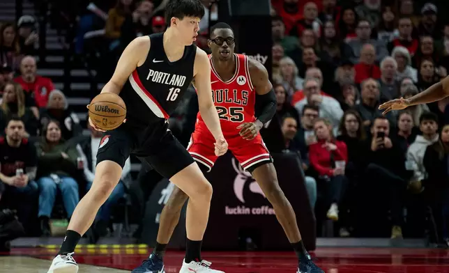 Portland Trail Blazers center Yang Hansen, left, posts up against Chicago Bulls center Jalen Smith during the second half of an NBA basketball game in Portland, Ore., Wednesday, Nov. 19, 2025. (AP Photo/Craig Mitchelldyer)