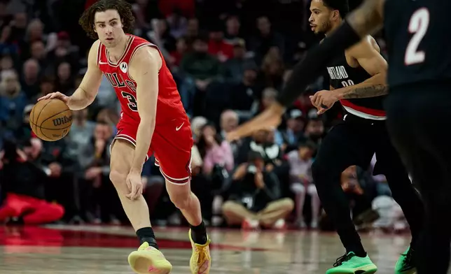 Chicago Bulls guard Josh Giddey, left, dribbles past Portland Trail Blazers forward Toumani Camara during the second half of an NBA basketball game in Portland, Ore., Wednesday, Nov. 19, 2025. (AP Photo/Craig Mitchelldyer)