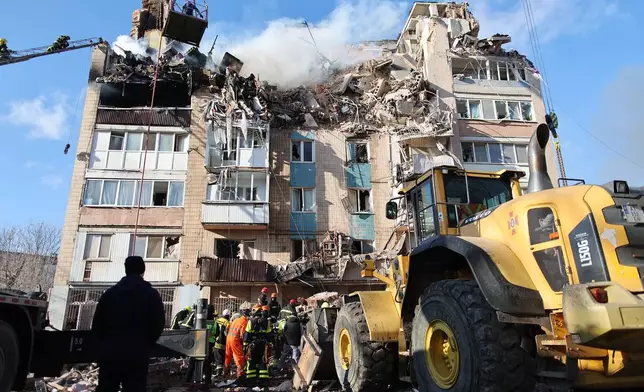 Rescue workers clear the rubble of a residential building which was heavily damaged by a Russian strike on Ternopil, Ukraine, on Wednesday, Nov. 19, 2025. (AP Photo/Vlad Kravchuk)