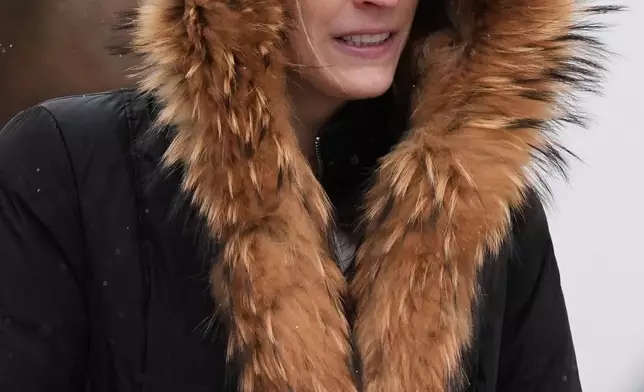 A pedestrian bundles up as she walks on the sidewalk during a snowy day in Chicago, Sunday, Nov. 9, 2025. (AP Photo/Nam Y. Huh)