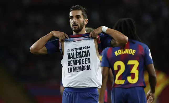 Barcelona's Ferran Torres shows a message in Spanish reading "29 October 2024, Valencia, always in our memory," as he celebrates after scoring his side's second goal during a Spanish La Liga soccer match between FC Barcelona and Elche CF in Barcelona, Spain, Sunday, Nov. 2, 2025. (AP Photo/Joan Monfort)