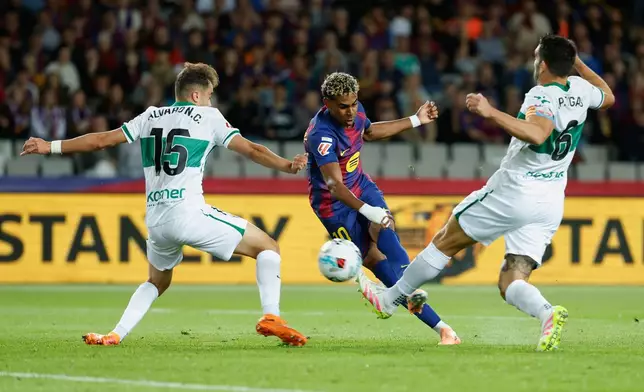 Barcelona's Lamine Yamal, center, scores his side's opening goal during a Spanish La Liga soccer match between FC Barcelona and Elche CF in Barcelona, Spain, Sunday, Nov. 2, 2025. (AP Photo/Joan Monfort)