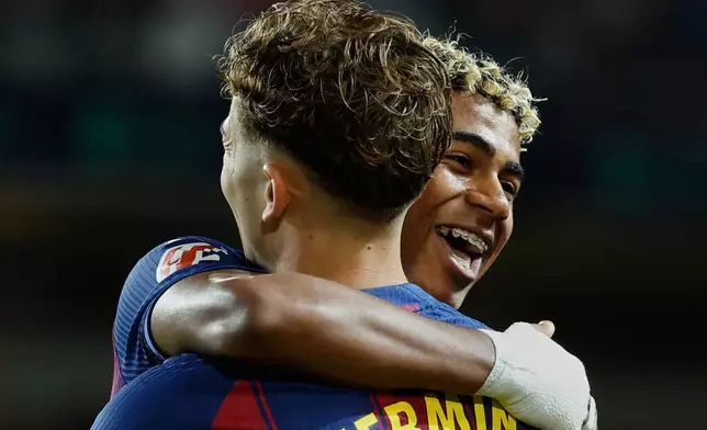 Barcelona's Lamine Yamal, right, celebrates with Barcelona's Fermin Lopez after their teammate Ferran Torres scored his side's second goal during a Spanish La Liga soccer match between FC Barcelona and Elche CF in Barcelona, Spain, Sunday, Nov. 2, 2025. (AP Photo/Joan Monfort)