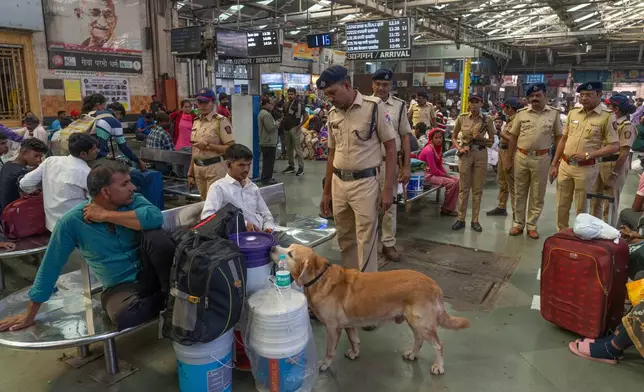 Security personnel along with a sniffer dog check the luggage of passengers at Chhatrapati Shivaji Terminus in Mumbai, India, as part of enhanced security following Monday's deadly car blast in the Indian capital, Tuesday, Nov. 11, 2025. (AP Photo/Rafiq Maqbool)