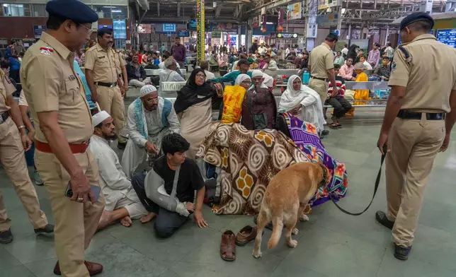 Security personnel along with a sniffer dog check the luggage of passengers at Chhatrapati Shivaji Terminus in Mumbai, India, as part of enhanced security following Monday's deadly car blast in the Indian capital, Tuesday, Nov. 11, 2025. (AP Photo/Rafiq Maqbool)