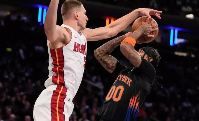 Miami Heat forward Nikola Jovic, left, defends against New York Knicks guard Jordan Clarkson (00) during the first half of an NBA Cup basketball game, Friday, Nov. 14, 2025, in New York. (AP Photo/Yuki Iwamura)
