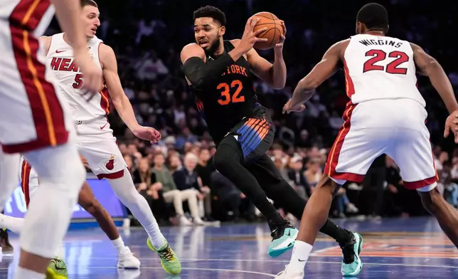 New York Knicks center Karl-Anthony Towns (32) drives past Miami Heat forward Nikola Jovic (5) during the first half of an NBA Cup basketball game, Friday, Nov. 14, 2025, in New York. (AP Photo/Yuki Iwamura)