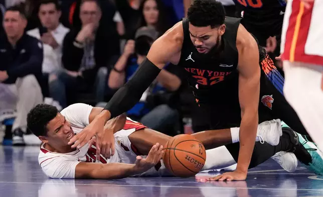 New York Knicks center Karl-Anthony Towns (32) fights for control of the ball with Miami Heat guard Dru Smith (12) during the first half of an NBA Cup basketball game, Friday, Nov. 14, 2025, in New York. (AP Photo/Yuki Iwamura)