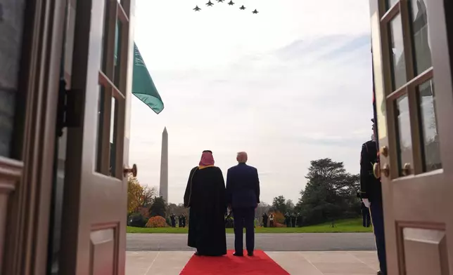 President Donald Trump and Saudi Arabia's Crown Prince Mohammed bin Salman watch a flight of F-35's and F-15's fly over during a welcome ceremony on the South Lawn of the White House, Tuesday, Nov. 18, 2025, in Washington. (AP Photo/Evan Vucci)