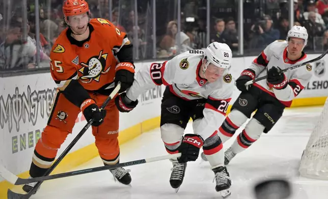 Anaheim Ducks defenseman Jacob Trouba, left, passes the puck away from Ottawa Senators left wing Fabian Zetterlund (20) during the second period of an NHL hockey game Thursday, Nov. 20, 2025, in Anaheim, Calif. (AP Photo/Jayne Kamin-Oncea)