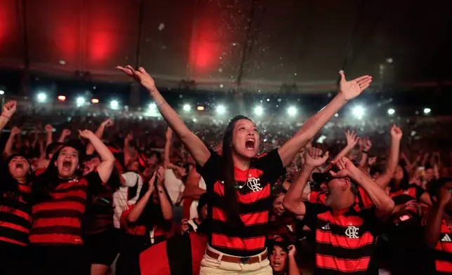 Fans of Brazil's Flamengo celebrate a goal as they watch the Copa Libertadores final soccer match against Brazil's Palmeiras, being played in Lima, Peru, on a giant screen set up at Maracana stadium in Rio de Janeiro, Saturday, Nov. 29, 2025. (AP Photo/Bruna Prado)