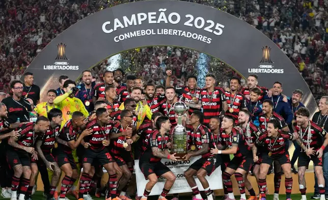 Players of Brazil's Flamengo celebrate with the trophy after defeating Brazil's Palmeiras in the Copa Libertadores final soccer match in Lima, Peru, Saturday, Nov. 29, 2025. (AP Photo/Martin Mejia)