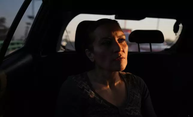 Ninfa Fuentes enters the back seat of a taxi organized by AmorrAs, a feminist transportation collective that offers rides to women who prefer alternatives to public transit due to safety concerns, in Mexico City, Thursday, Nov. 6, 2025. (AP Photo/Claudia Rosel)
