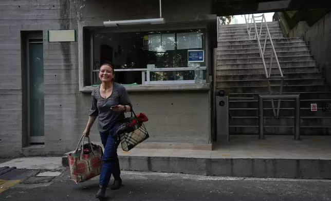 Ninfa Fuentes leaves work in the Santa Fe neighborhood of Mexico City to head home to the State of Mexico, Thursday, Nov. 6, 2025. (AP Photo/Claudia Rosel)