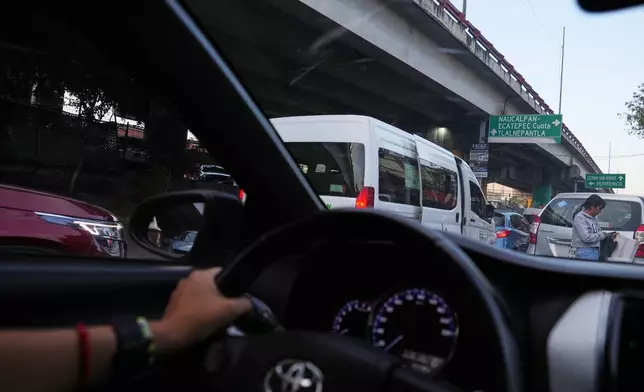 Diana Guzman, a driver with AmorrAs, a feminist transportation collective that offers rides to women who prefer alternatives to public transit due to safety concerns, drives a passenger home in the State of Mexico, Thursday, Nov. 6, 2025. (AP Photo/Claudia Rosel)