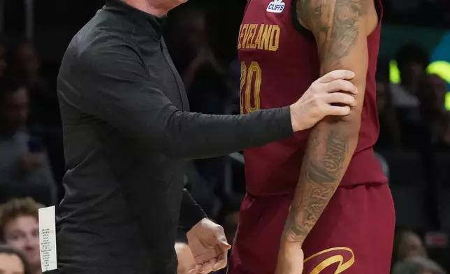Cleveland Cavaliers head coach Kenny Atkinson talks to guard Jaylon Tyson (20) during the first half of an NBA basketball game against the Miami Heat Monday, Nov. 10, 2025, in Miami. (AP Photo/Marta Lavandier)