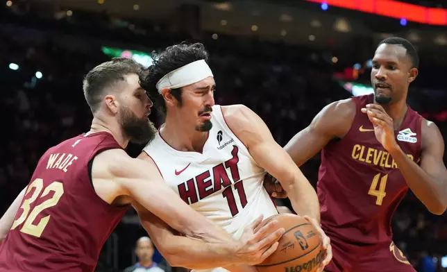 Miami Heat forward Jaime Jaquez Jr. (11) and Cleveland Cavaliers forward Dean Wade (32) go after a rebound during the first half of an NBA basketball game Monday, Nov. 10, 2025, in Miami. (AP Photo/Marta Lavandier)