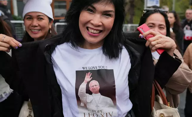 A woman shows her t-shirt as she arrives for a Mass led by Pope Leo XIV at the Volkswagen Arena venue, in Istanbul, Turkey, Saturday, Nov. 29, 2025. (AP Photo/Dilara Acikgoz)