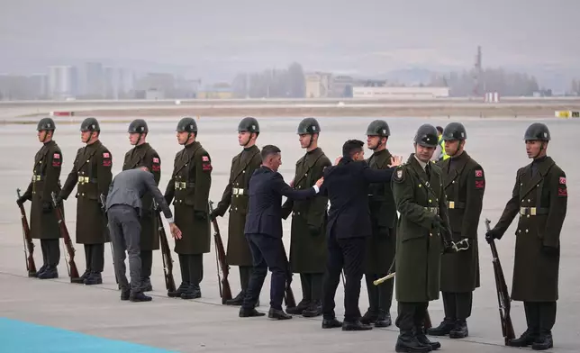 A Turkish honor guard prepares ahead of the arrival of the papal plane carrying Pope Leo XIV at Esenboga International Airport in Ankara, Turkey, Thursday, Nov. 27, 2025, marking the start of his first foreign trip. (AP Photo/Khalil Hamra)