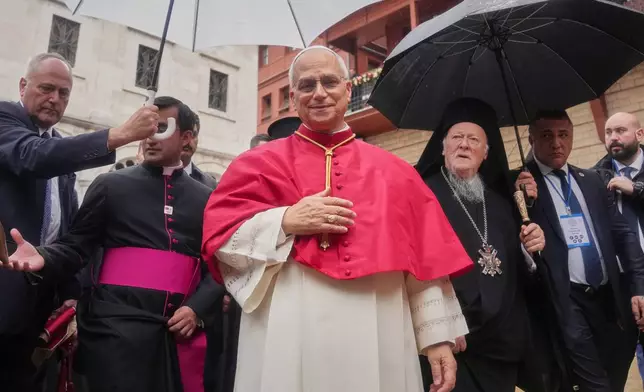 Pope Leo XIV and Ecumenical Patriarch Bartholomew I, the spiritual leader of the world's Eastern Orthodox Christians leave after a doxology service at the Patriarchal Church of Saint George, in Istanbul, Turkey, Saturday, Nov. 29, 2025. (AP Photo/Francisco Seco)
