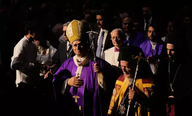 Pope Leo XIV arrives with Ecumenical Patriarch Bartholomew I, the spiritual leader of the world's Eastern Orthodox Christians to celebrate a Mass at the Volkswagen Arena, in Istanbul, Turkey, Saturday, Nov. 29, 2025. (AP Photo/Khalil Hamra)