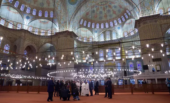 Pope Leo XIV, in the background center, visits the Ottoman-era Sultan Ahmed (Blue) Mosque in Istanbul, Turkey, Saturday, Nov. 29, 2025. (AP Photo/Domenico Stinellis)