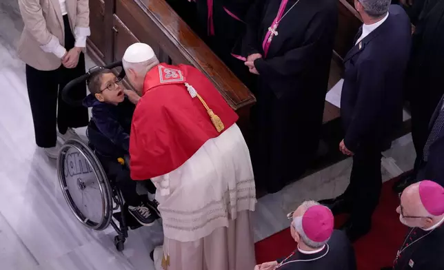 Pope Leo XIV greets a child as he meets the clergy at the Cathedral of the Holy Spirit, in Istanbul, Turkey, Friday, Nov. 28, 2025. (AP Photo/Domenico Stinellis)