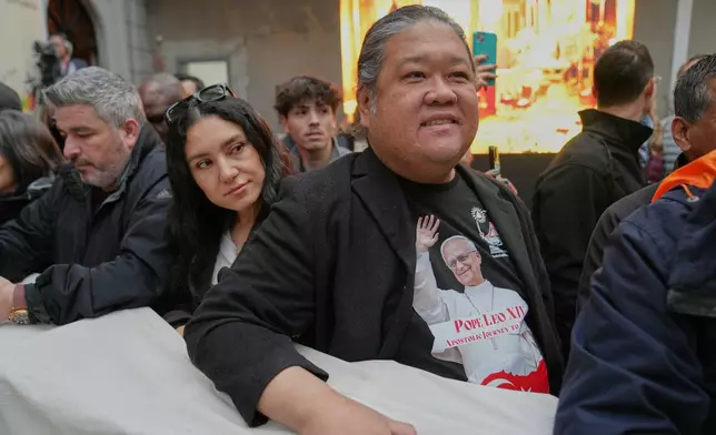 People wait for the arrival of Pope Leo XIV for a meeting with the clergy at the Cathedral of the Holy Spirit, in Istanbul, Turkey, Friday, Nov. 28, 2025. (AP Photo/Domenico Stinellis)